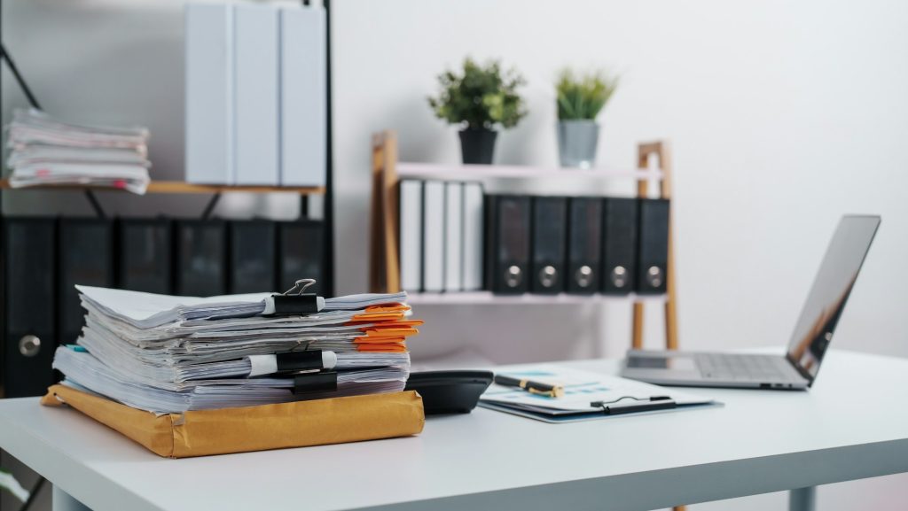 Stylish workspace with laptop, notebook, blank screen laptop on white table of bookkeeping.